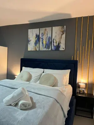 a bedroom with a blue bed with towels on it at Apartments Indigo in Jajce