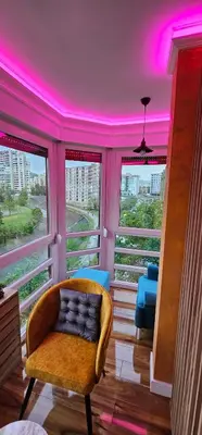 a room with a chair and windows with pink lighting at Smart Lux in Tuzla