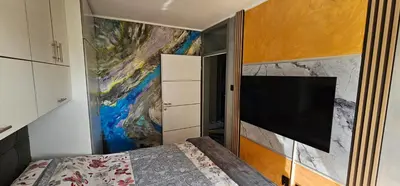 a bedroom with a tv and a painting on the wall at Smart Lux in Tuzla
