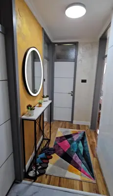 a hallway with a mirror and a door with a rug at Smart Lux in Tuzla
