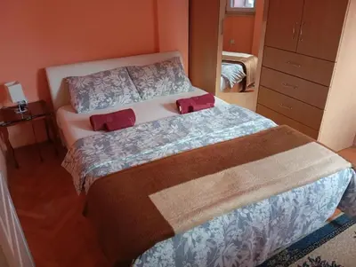 a bedroom with a bed with two red pillows at Kiki in Banja Luka