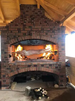 a brick fireplace with a fire in it at Suncev Brijeg in Banja Luka