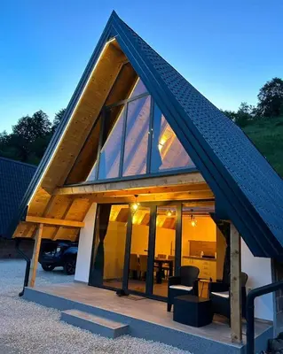 a house with a roof with glass doors at Bungalov Mila in Šipovo