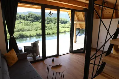 a living room with a view of a river at Bungalov Mila in Šipovo