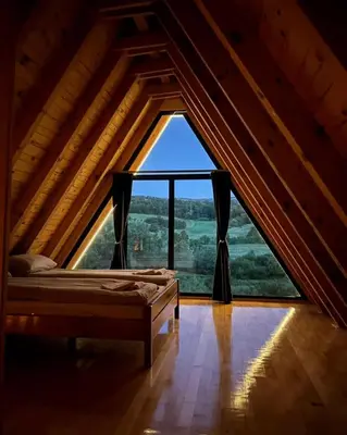 a bed in a room with a large window at Bungalov Mila in Šipovo