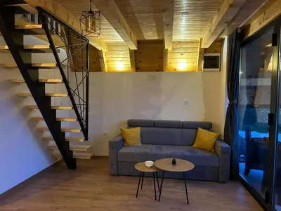a living room with a couch and a staircase at Bungalov Mila in Šipovo