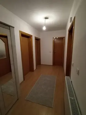 an empty room with a hallway with doors and a rug at Gold Home in Bosanska Gradiška