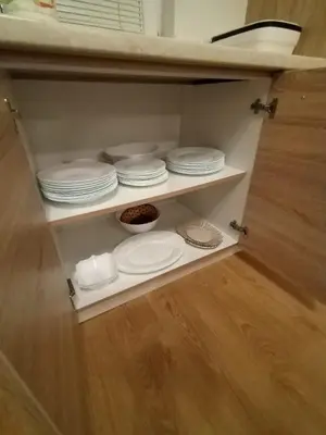 a cupboard with plates and dishes in it at Gold Home in Bosanska Gradiška