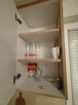 a cupboard with jars and other kitchen items on it at Gold Home in Bosanska Gradiška