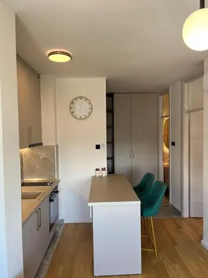 a kitchen with a counter and a clock on the wall at Green Lux Apartman Prijedor in Prijedor