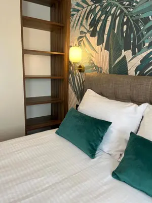 a bedroom with a bed with two green pillows at Green Lux Apartman Prijedor in Prijedor
