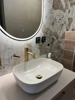 a white sink in a bathroom with a mirror at Green Lux Apartman Prijedor in Prijedor