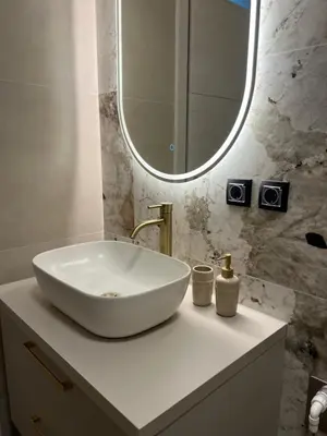 a bathroom with a white sink and a mirror at Green Lux Apartman Prijedor in Prijedor