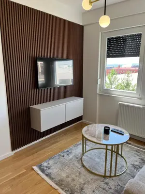 a living room with a coffee table and a tv at Green Lux Apartman Prijedor in Prijedor