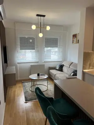 a living room with a couch and a table at Green Lux Apartman Prijedor in Prijedor
