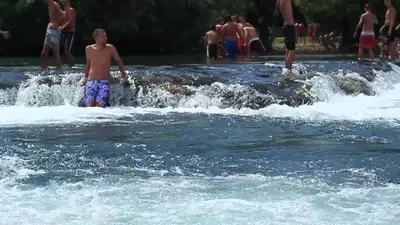 a group of people standing in a body of water at The Urbanite in Bihać