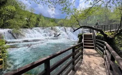 a staircase leading to a waterfall next to a river at The Urbanite in Bihać