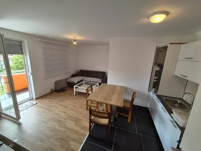 a kitchen and living room with a table and a couch at The Urbanite in Bihać