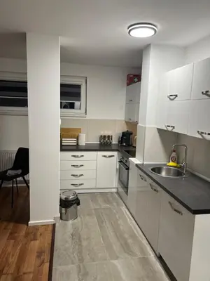 a kitchen with white cabinets and a sink at Apartman Nora in Teslić