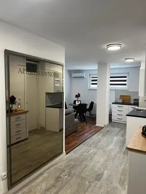 a kitchen and dining room with a table and a mirror at Apartman Nora in Teslić