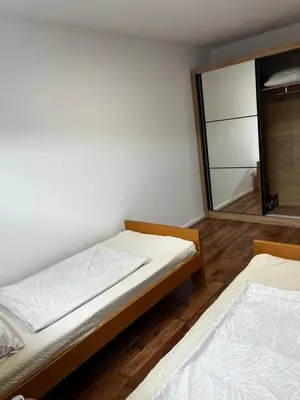 two beds in a room with a mirror at Apartman Nora in Teslić