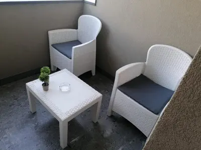 two chairs and a table in a room at Apartman Nora in Teslić