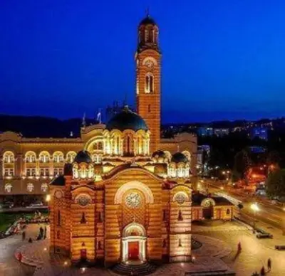 a large building with a clock tower at night at Vikendica Anastasija in Laktaši