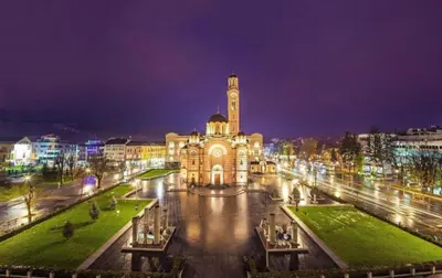 a large building with a clock tower at night at Vikendica Anastasija in Laktaši