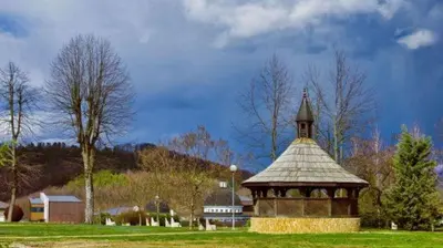 a gazebo with a clock tower in a field at Vikendica Anastasija in Laktaši