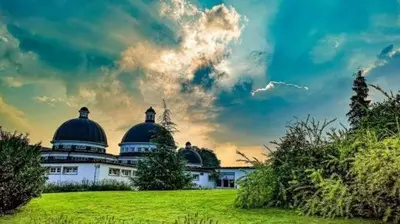 a large white building with domes on a green field at Vikendica Anastasija in Laktaši