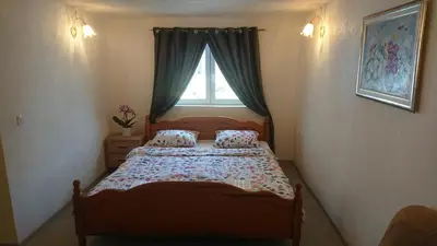 a small bedroom with a bed with a window at Delux Apartmans in Kulen Vakuf
