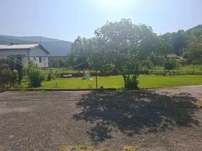 a tree in the middle of a yard at Delux Apartmans in Kulen Vakuf