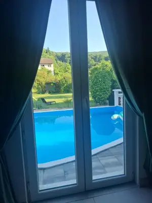 a window with a view of a swimming pool at Delux Apartmans in Kulen Vakuf