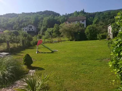 a playground in a yard with a green lawn at Delux Apartmans in Kulen Vakuf