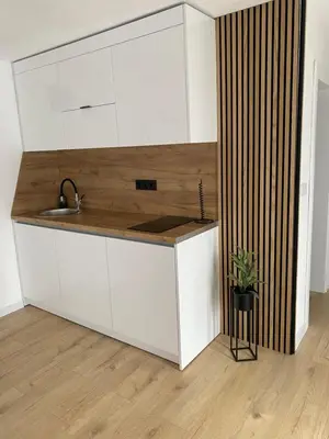 a kitchen with white cabinets and a sink at Apartman Rawda 1 in Jajce