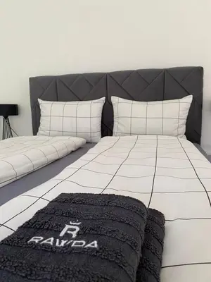 a bedroom with a bed with a black and white blanket at Apartman Rawda 1 in Jajce
