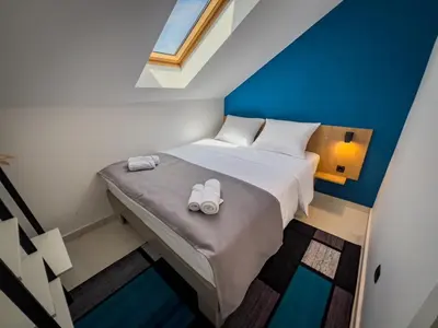 a small bedroom with a bed with two white slippers at Sunny Corner Apartments in Visoko