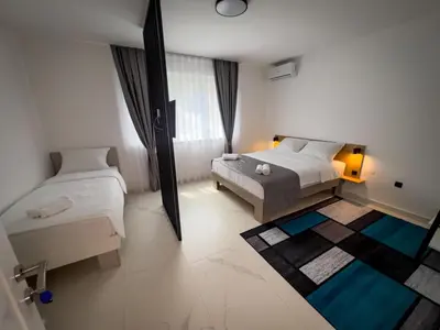 a bedroom with two beds and a large window at Sunny Corner Apartments in Visoko