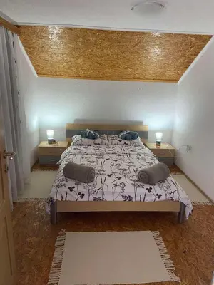 a bedroom with a large bed with two night stands at Villa Seferovka in Kulen Vakuf