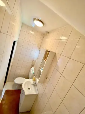 a bathroom with a white toilet and a sink at Apartman MyHome Travnik in Travnik