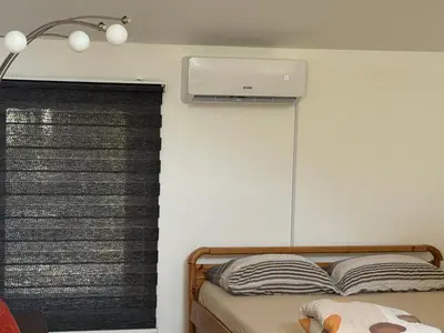 a bedroom with a bed with a air conditioner on the wall at Apartman MyHome Travnik in Travnik