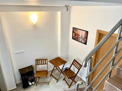 a room with two chairs and a table and stairs at Apartman MyHome Travnik in Travnik