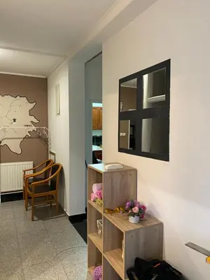 a room with a table and a mirror on a wall at Adnna Home in Bihać