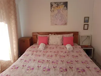 a bedroom with a large bed with pink pillows at Adnna Home in Bihać