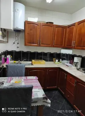 a kitchen with wooden cabinets and a table in it at Adnna Home in Bihać