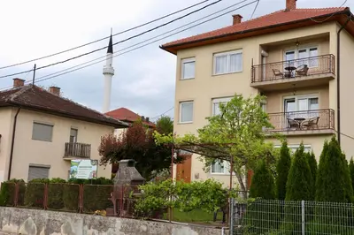 an apartment building with a tv tower in the background at Green River Rooms in Šipovo