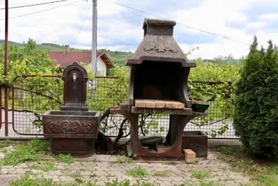 an old stove in a yard next to a fence at Green River Rooms in Šipovo