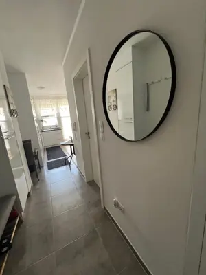 a hallway with a round mirror on the wall at Apartman Jan in Bihać
