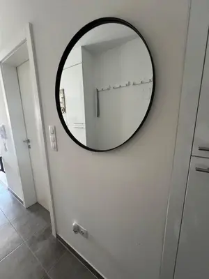 a mirror on a white wall in a room at Apartman Jan in Bihać