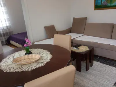 a living room with a table and a couch at Apartman Jan in Bihać